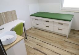 Behandlungszimmer mit Liege in thematischer Farbgebung