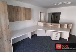 Bürobereich mit maßgefertigtem Eckschreibtisch, Rollcontainer, Hängeschrank und Empfangsaufsatz in Eichenoptik.