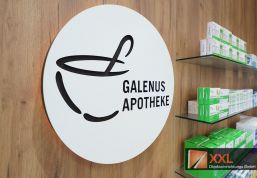 Das Galenus-Logo an der Holzwand setzt einen ruhigen, hochwertigen Markenakzent.