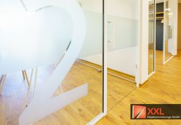Der zweite Wartebereich – lichtdurchflutet, modern und klar strukturiert mit großflächiger Glasbeschriftung.