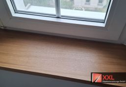 Detailansicht der maßgefertigten Fensterbank mit sauber verarbeiteter Kante in Eichenoptik.