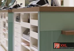 Effiziente Arbeitsbereiche: Strukturiertes Arbeiten mit klar angeordneten Fächern für Medikamente und Rezeptverarbeitung – ein Blick hinter die Kulissen der Apotheke.