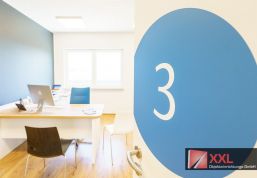 Ein weiteres modern ausgestattetes Behandlungszimmer mit ergonomischem Arbeitsplatz, großem Fenster und durchdachtem Farbkonzept – hell, ruhig, professionell.