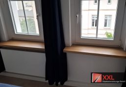 Fensterbänke in Eichenoptik über den Heizkörpernischen, exakt an die vorhandene Bausubstanz angepasst.