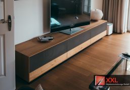 Gesamtansicht des TV-Boards mit warmen Holzelementen
