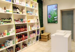 Geschwungene Regale in der Apothekeneinrichtung ziehen Blicke auf Waren und Angebote