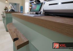 Kundennahes Design: Warme Holzelemente und moderne Technik verbinden sich zu einer angenehmen, kundenfreundlichen Umgebung.