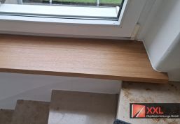 Maßgefertigte Fensterbank im Treppenhaus – millimetergenau eingepasst in die schräge Laibung.
