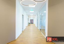 Offener Korridor mit hochwertigem Vinylboden und auffälliger Lichtinstallation – verbindet Funktionalität mit architektonischer Eleganz.