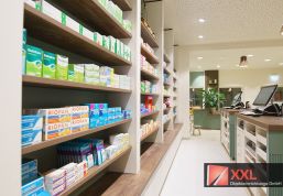 Optimale Regalsysteme: Geschmackvoll gestaltete Holzregale mit integrierter Beleuchtung präsentieren eine große Auswahl an Gesundheitsprodukten in modernem Design.