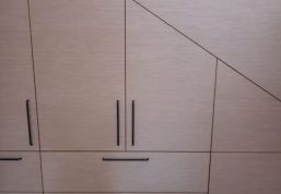 Professionell verarbeiteter und optisch dezenter Einbauschrank unter einer Dachschräge