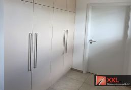 Schlichte Einbauschränke mit eleganten Edelstahlgriffen – optimaler Stauraum für Flure oder Büros mit minimalistischem Design.