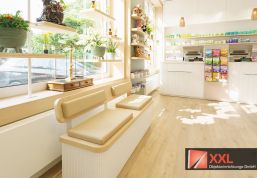 Sitzgelegenheit für wartende oder ältere Kundschaft mit Blick in den großzügigen Innenraum der Apotheke