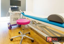 Untersuchungsraum mit moderner Ultraschalltechnik und höhenverstellbarer Liege.