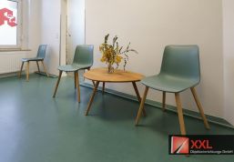 Wartebereich mit runder Sitzgruppe und frischem Grün – hochwertig und einladend.